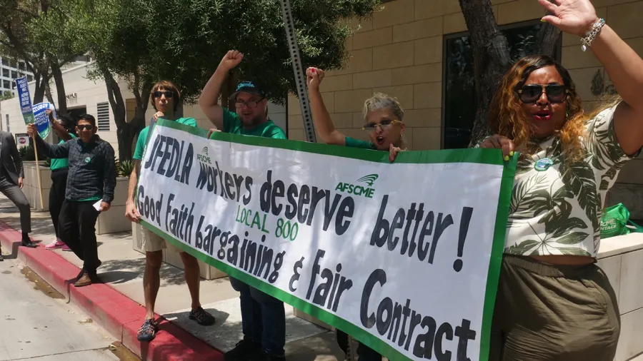 Photo of AFSCME Local 800 picket attendees holding a banner that reads in part JFEDLA Workers deserve better